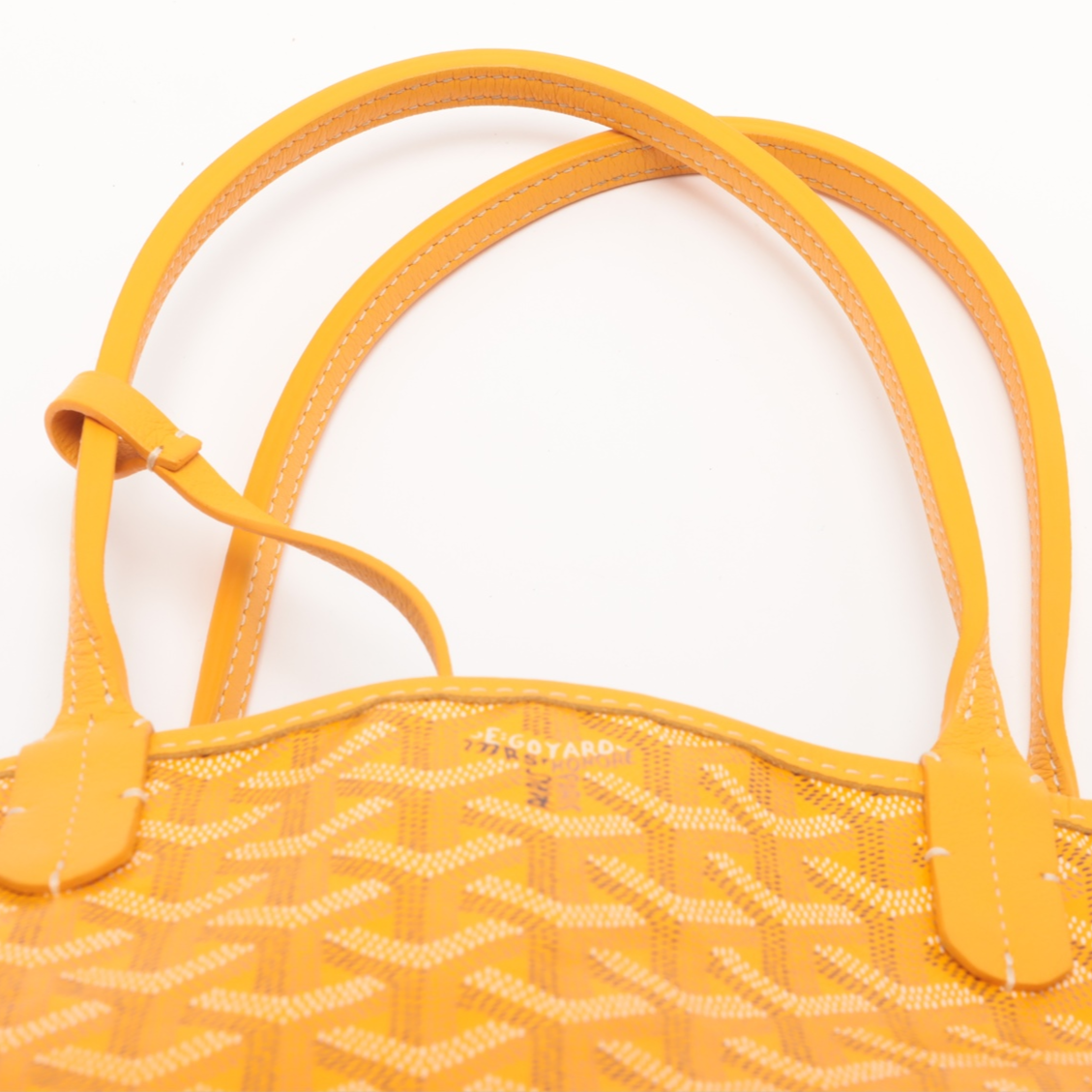 Yellow woven handbag with a visible brand logo on a white background